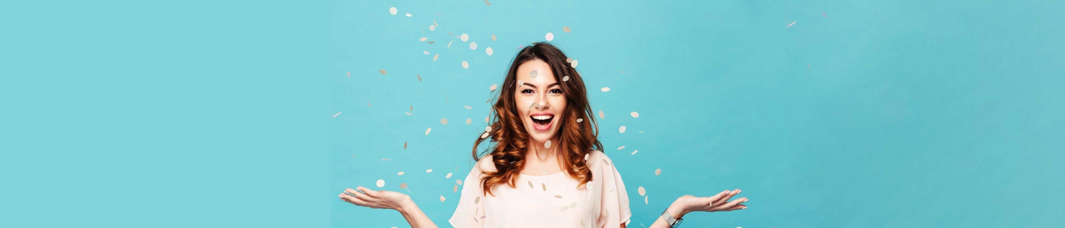 Woman in light dress, in front of a blue background, with confetti falling