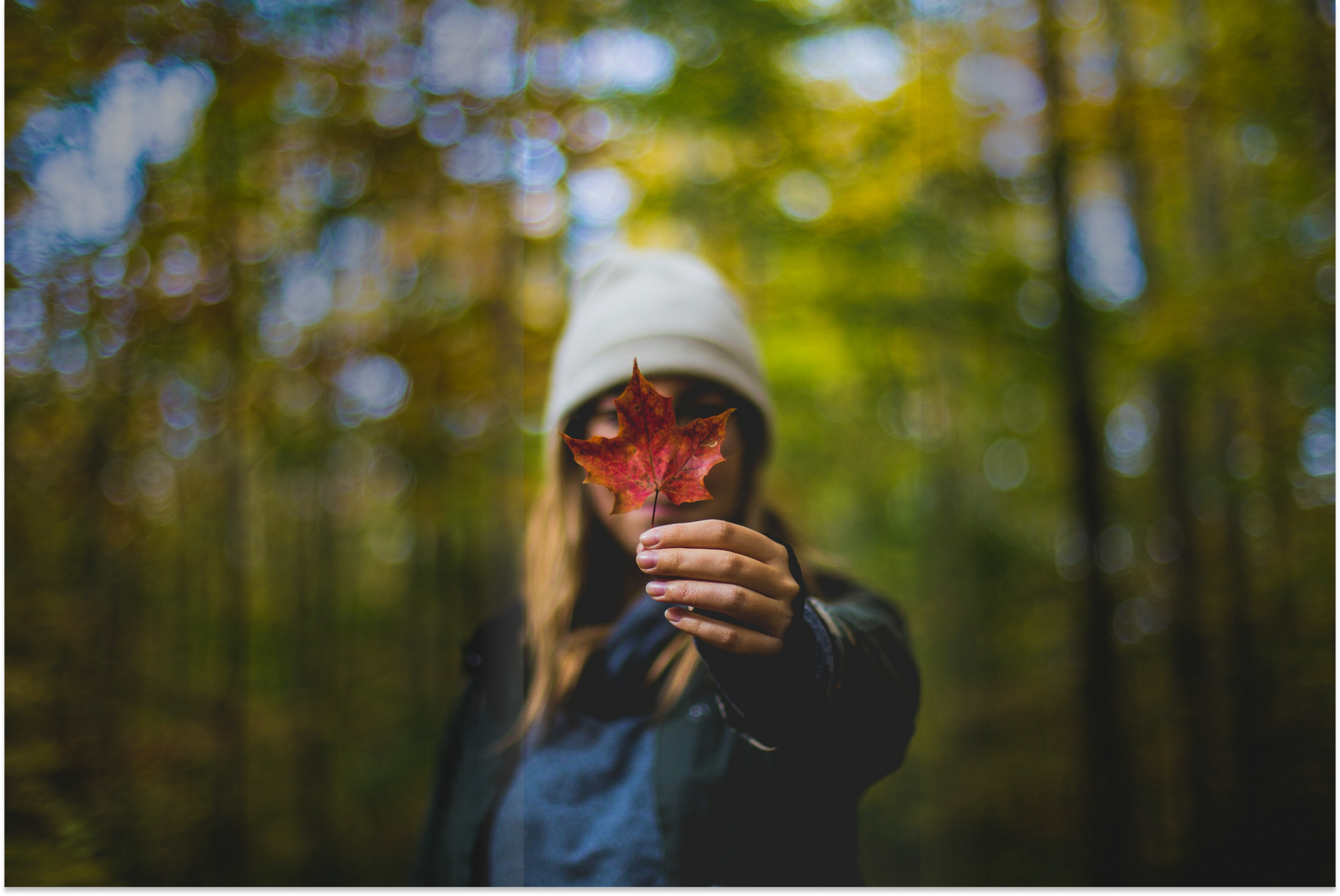 Woman in a light hat, holding a maple leaf