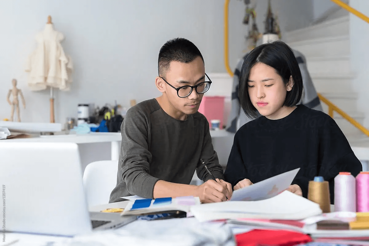 Two people writing on paper