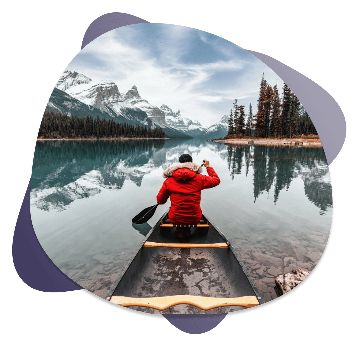 People canoeing on a lake with mountains in the background