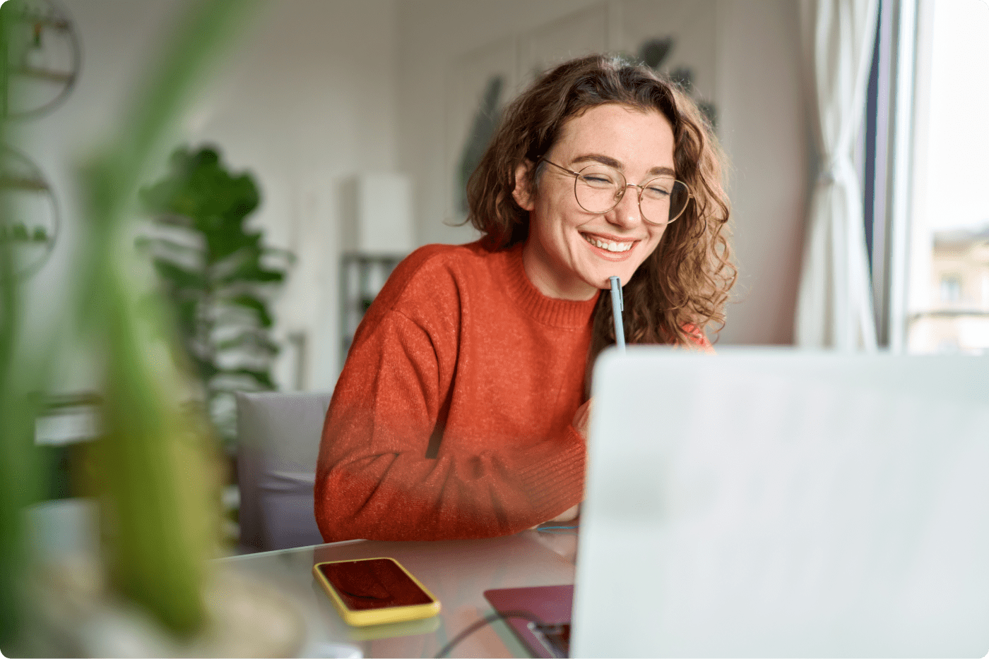 A photo of woman looking at laptop smiling